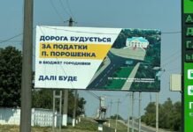 Білборд у Городківці з написом «Дорога будується за податки П. Порошенка» на тлі сільської дороги