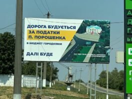 Білборд у Городківці з написом «Дорога будується за податки П. Порошенка» на тлі сільської дороги